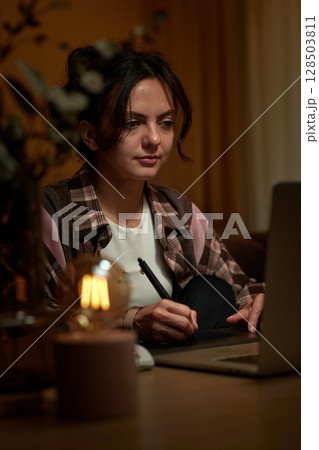 beautiful graphic designer woman working at home office remotely using digital graphic tablet and laptop 128503811