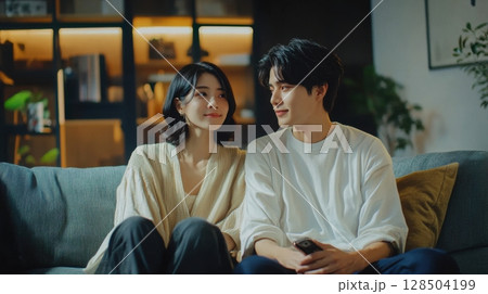 Couple Relaxing on Sofa at Home Watching TV Together Couple Relaxing on Sofa at Home Watching TV Together 128504199
