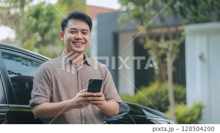 Happy Man Using Smartphone Near His Car Happy Man Using Smartphone Near His Car 128504200
