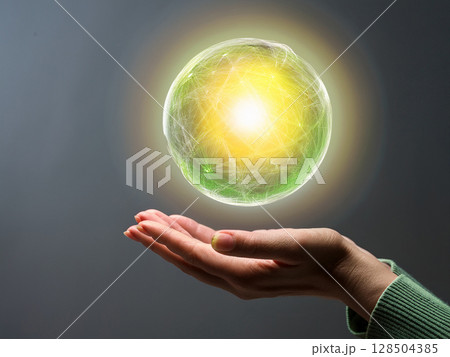 手のひらに浮かぶ抽象的な黄緑色の球体 128504385