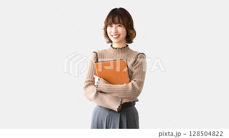 バインダーを持つ笑顔の女性・ビジネスウーマン バインダーを持つ笑顔の女性・ビジネスウーマン 128504822