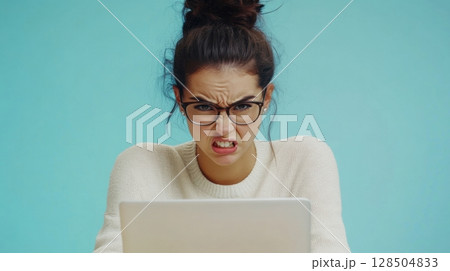 frustrated woman working on laptop 128504833