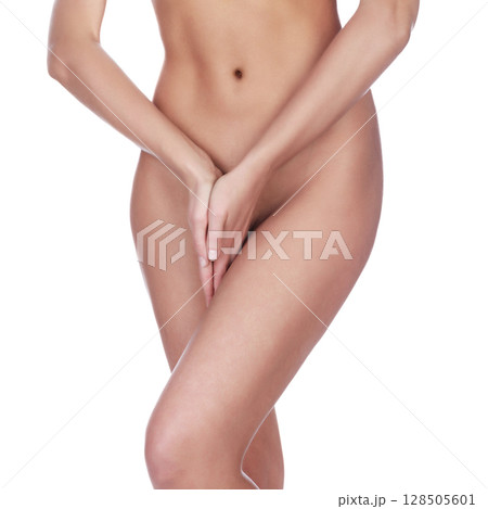 Closeup shot of woman holding her hands between the legs, isolated Closeup shot of woman holding her hands between the legs, isolated 128505601