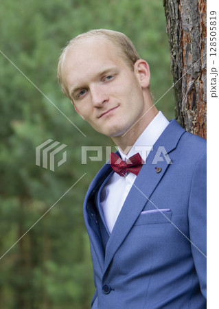 Portrait of the groom of European appearance in a blue wedding suit. 128505819