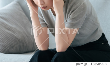 頭を押さえて悩む女性 128505899