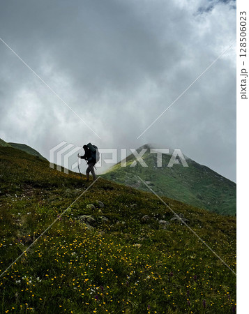 Silhouette of a lone tourist over a cliff. Silhouette of a lone tourist over a cliff. 128506023