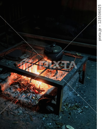 Coffee pot on camping fire at night Coffee pot on camping fire at night 128506025