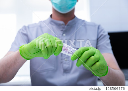 Close-up of a Professional in Green Gloves Preparing Medical Equipment in a Clean Environment for Patient Care and Safety in a Modern Healthcare Setting 128506376