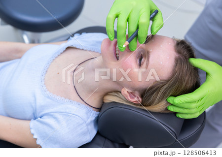 Clinical Setting: Patient Receiving Cosmetic Treatment with a Focus on Facial Enhancements for Beauty and Wellness in a Modern Medical Environment Clinical Setting: Patient Receiving Cosmetic Treatment with a Focus on Facial Enhancements for Beauty and Wellness in a Modern Medical Environment 128506413