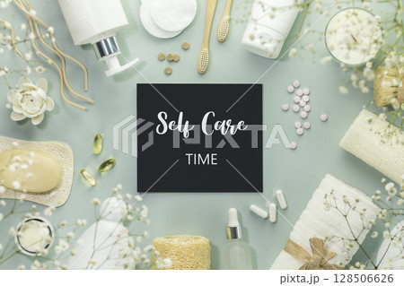 Eco friendly spa relax composition with beauty products, serums, soap, accessories and supplements on blue background with chalkboard with text Self Care Time. Concept of me time, wellness, self care 128506626
