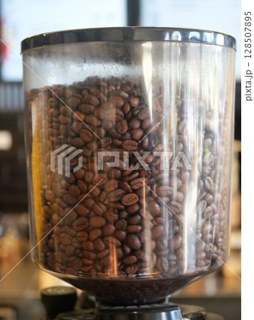 Intimate CloseUp of Coffee Beans Situated Within Grinding Container 128507895