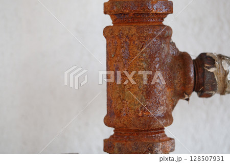 Rusty pipe fitting showing signs of age and wear 128507931