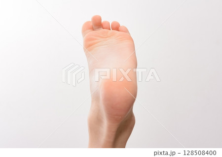 Close-up of a clean, healthy foot sole against a white background. Soft, smooth skin is visible. 128508400