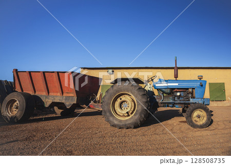 An agricultural tractor without cab in parking lot in hot country. 128508735