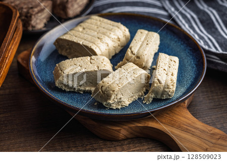Halva. Sweet oriental dessert on plate on wooden table. Halva. Sweet oriental dessert on plate on wooden table. 128509023