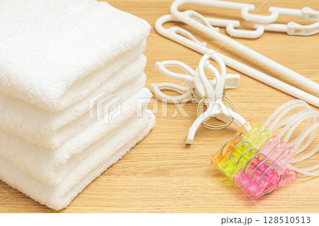 積まれたタオルとハンガーと洗濯ばさみ 128510513