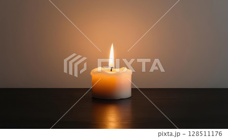 glowing candle illuminating dark room, symbolizing inner light and spirituality 128511176
