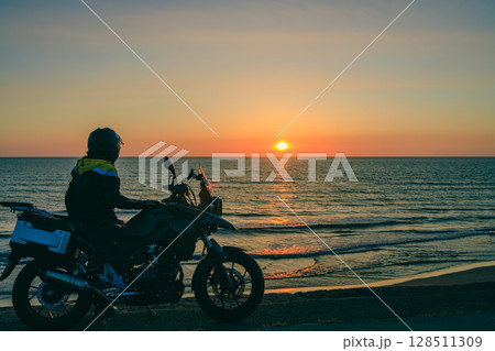 日本海に沈む夕陽とバイクとライダー 128511309