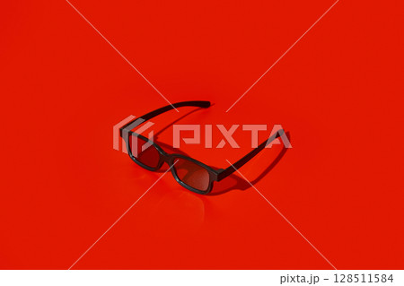 Black plastic 3d glasses on red background with copy space 128511584