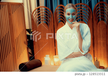 Woman indulges in rejuvenating with luxurious face cream spa massage. Quiescent Woman indulges in rejuvenating with luxurious face cream spa massage. Quiescent 128513311