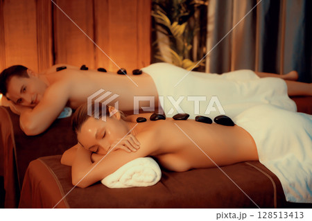 Hot stone massage at spa salon in luxury resort with warm candle light.Quiescent Hot stone massage at spa salon in luxury resort with warm candle light.Quiescent 128513413