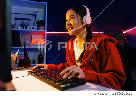 Host channel smiling Asian wearing headphone recording on phone. Stratagem. Host channel smiling Asian wearing headphone recording on phone. Stratagem. 128513510