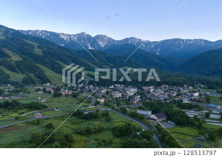 夏の早朝の白馬三山と白馬村のホテル街 長野県白馬村(ドローンによる空撮) 夏の早朝の白馬三山と白馬村のホテル街 長野県白馬村(ドローンによる空撮) 128513797