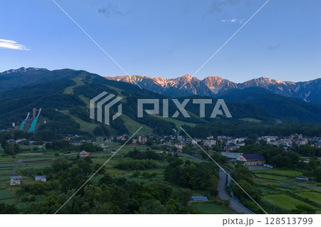 白馬三山のモルゲンロートと夏の白馬村　長野県白馬村（ドローンによる空撮） 128513799