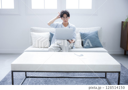 パソコンを見ながら考える男性困る悩むの表情の広角	 128514150