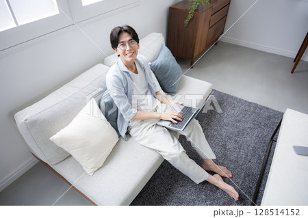 リビングでパソコンをする男性の俯瞰のカメラ目線 128514152