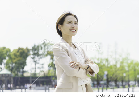 屋外で腕組みをして立つ若いビジネスウーマンのポートレート 屋外で腕組みをして立つ若いビジネスウーマンのポートレート 128514223