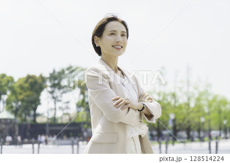 屋外で腕組みをして立つ若いビジネスウーマンのポートレート 128514224