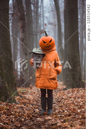 Girl with spooky pumpkin mask with scarecrow severed head 128514542