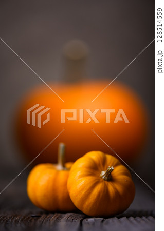 Large and small orange pumpkins on old wooden table. 128514559