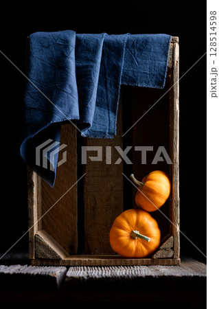 Two small decorative orange Baby Boo pumpkins in wooden box Two small decorative orange Baby Boo pumpkins in wooden box 128514598