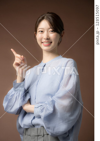 茶色い背景でビジネスシーンに使いやすい笑顔の女性　ナンバーワン(no1)やオススメやポイント	 128515097