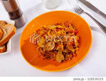 Stewed cabbage with mushrooms served on platter 128516125