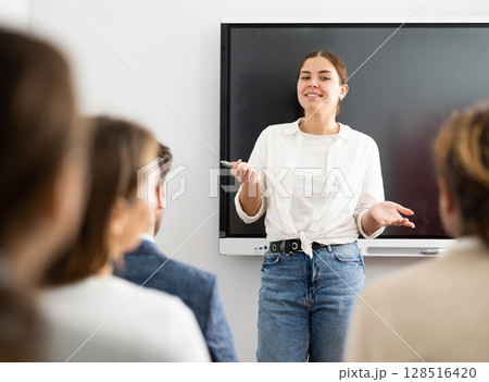 Young female teacher giving lecture to group of student Young female teacher giving lecture to group of student 128516420