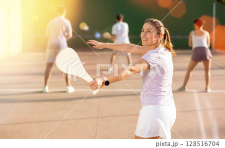 Woman Basque pelota player hitting ball with wooden racket Woman Basque pelota player hitting ball with wooden racket 128516704