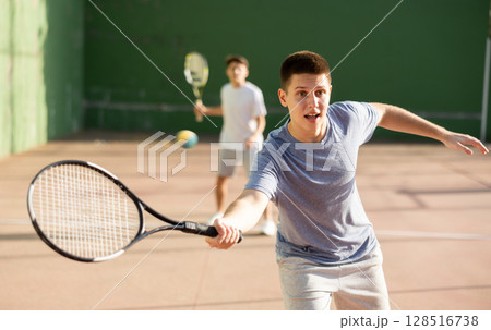 Emotional guy playing frontenis on open court on summer day 128516738