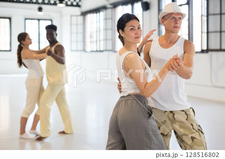 Four dancers exercising bachata movements Four dancers exercising bachata movements 128516802