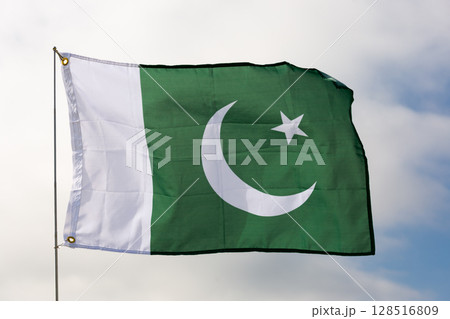 Pakistani flag flying beautifully in wind with gray sky behind 128516809