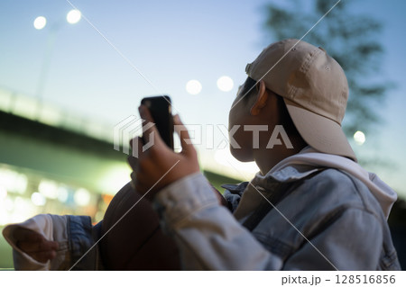 ブルーアワーの夕方にバスケットボールを持ってsns投稿や写真を撮る男の子 縦 ブルーアワーの夕方にバスケットボールを持ってsns投稿や写真を撮る男の子 縦 128516856