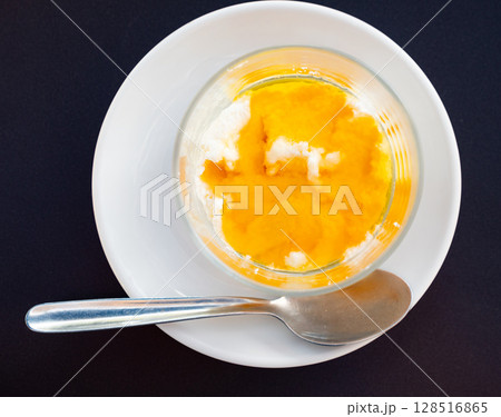 Farm cottage cheese filled with large amount of honey is served in transparent glass Farm cottage cheese filled with large amount of honey is served in transparent glass 128516865