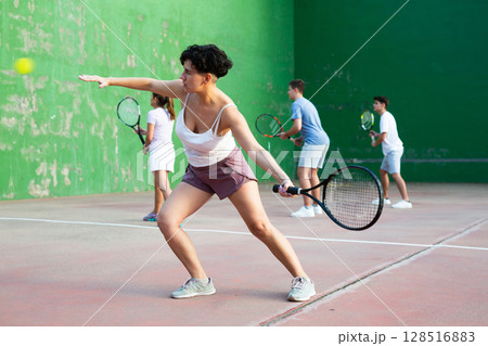 Expressive resolved fit girl playing frontenis ball friendly match on court 128516883