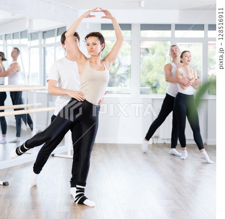 Amateur ballet partners mastering paired technique at group class 128516911
