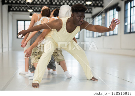 Group of young people learning modern dance movements 128516915