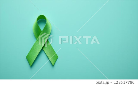 Green awareness ribbon on blue, highlighting the importance of mental health, self-care, and emotional resilience 128517786