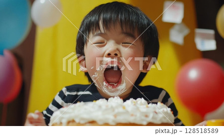 Cute asian boy eating a birthday cake at the party. Cute asian boy eating a birthday cake at the party. 128518589