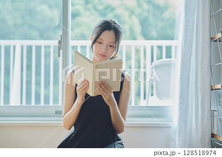 窓辺で本を読む女性 窓辺で本を読む女性 128518974